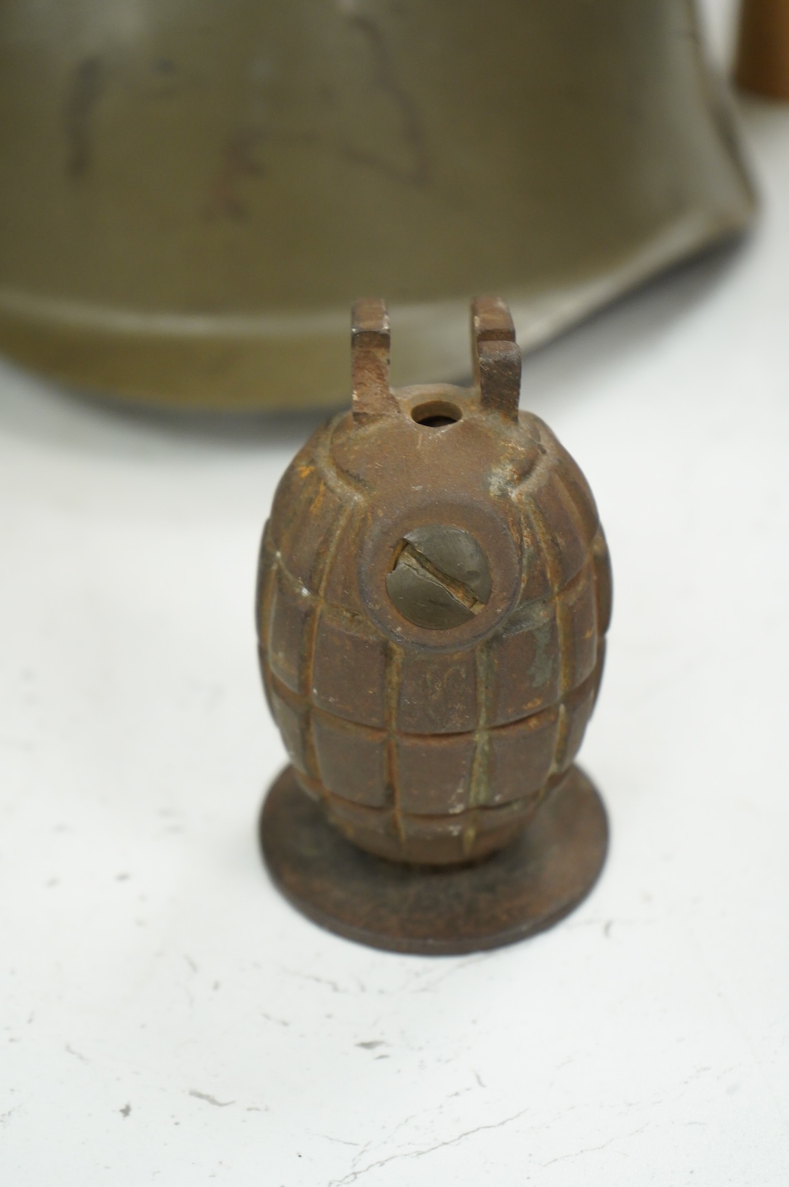 A Czech Vz53 tin helmet with liner, a Kris with applied presentation plaque engraved with ‘Presented by 'C' Battery’ and an inert British Mills hand grenade